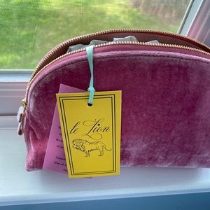 Magenta-colored XOXO pouch bag with gold zipper.